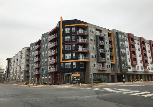 Dulles Station Parcel apartment complex in Virginia as seen from the street with a 'now leasing' sign.